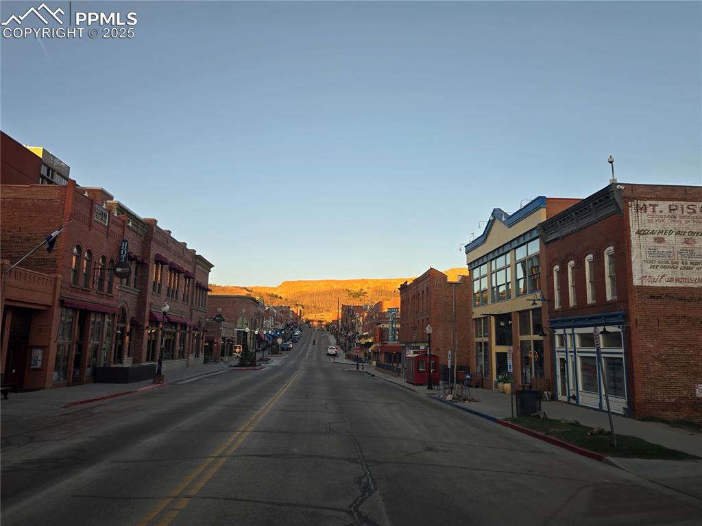 Image 10 of 10: View of asphalt street featuring sidewalks, curbs, and street lights