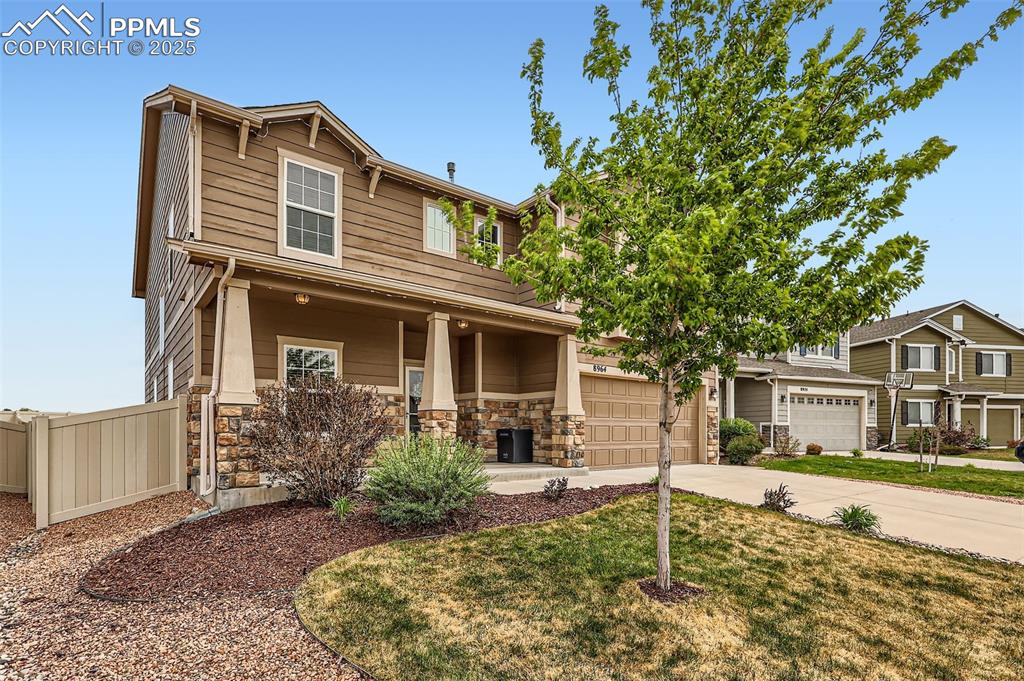 Caption: Craftsman house with concrete driveway, stone siding, and a porch