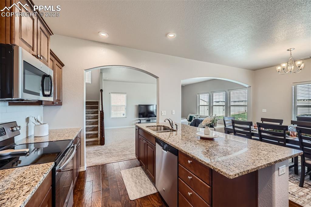 Image 10 of 29: Kitchen with appliances with stainless steel finishes, open floor plan, arc