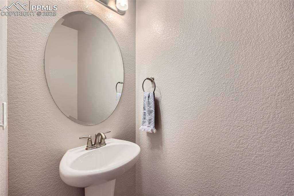 Image 13 of 29: Bathroom with a sink and a textured wall