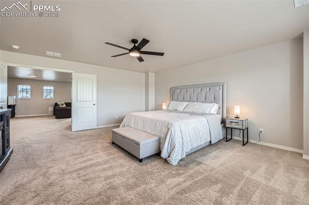 Image 16 of 29: Carpeted bedroom with baseboards and ceiling fan