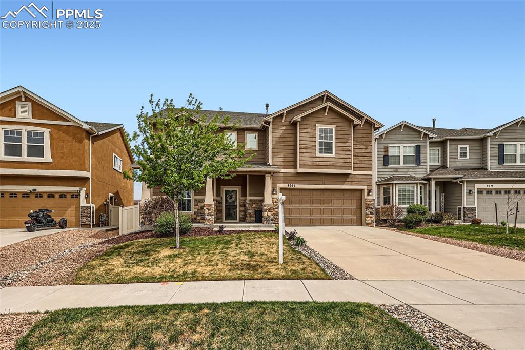 Image 2 of 29: View of front of home with a garage, concrete driveway, and stone siding