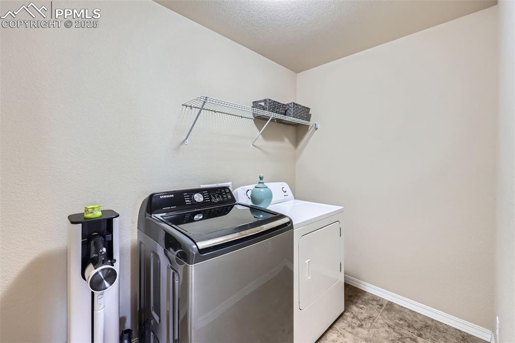 Image 23 of 29: Washroom with washing machine and dryer and baseboards