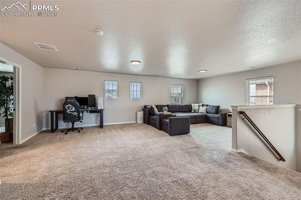 Image 24 of 29: Living room with light carpet, an office area, healthy amount of natural li