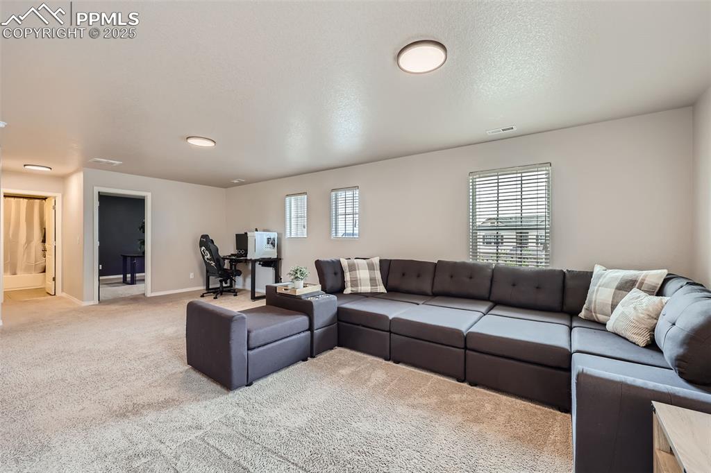Image 26 of 29: Living room featuring light colored carpet and baseboards