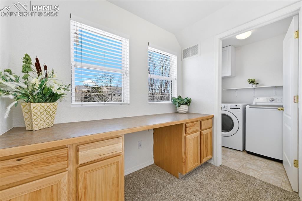 Image 23 of 41: Built in desk and storage outside laundry room in loft area