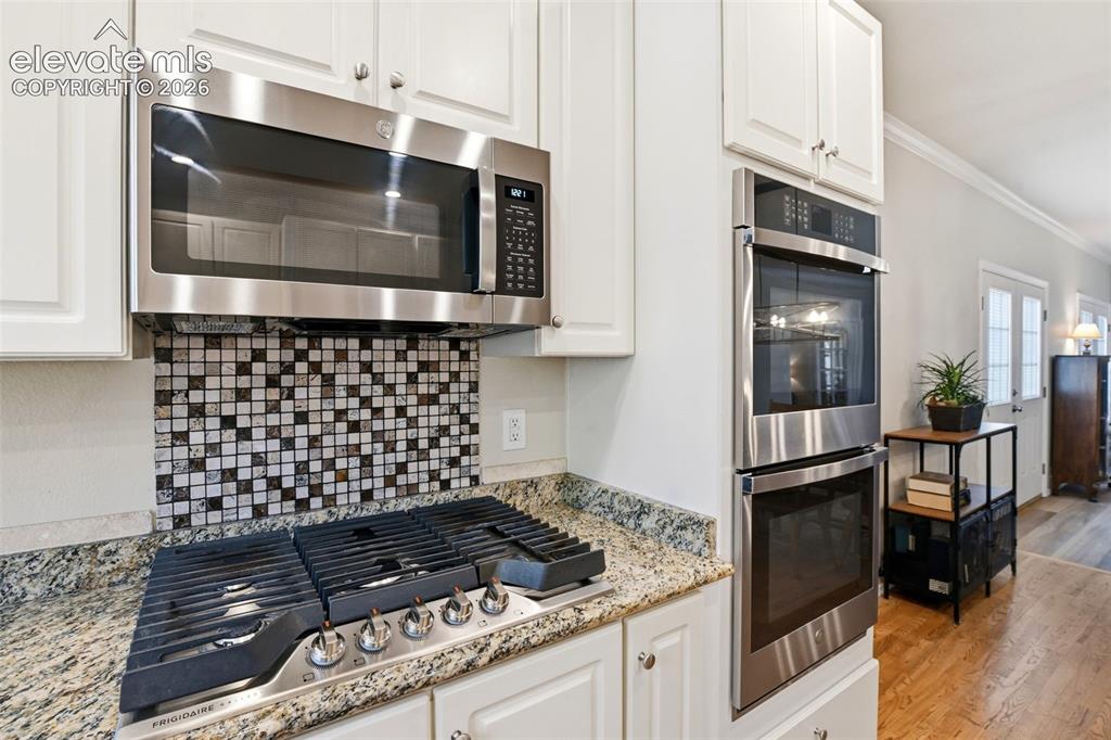 Image 11 of 40: Custom tile backsplash and double wall ovens