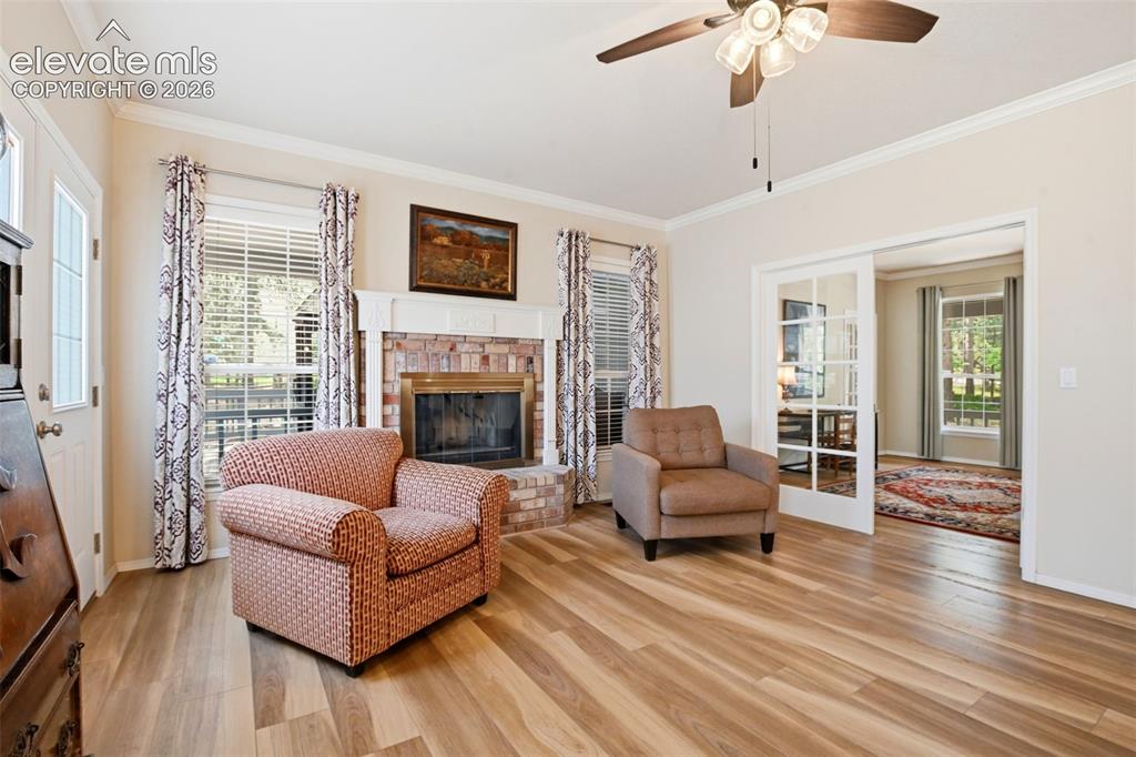 Image 16 of 40: Great room with gas log fireplace and brick surround leads to the office an