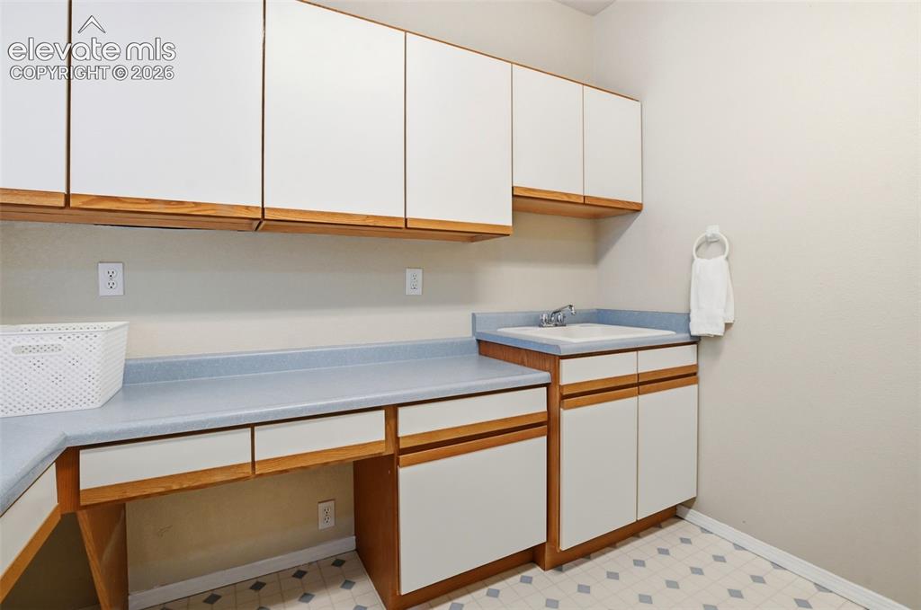 Image 18 of 40: Big main level laundry with a utility sink, tons of storage, a walk-in pan