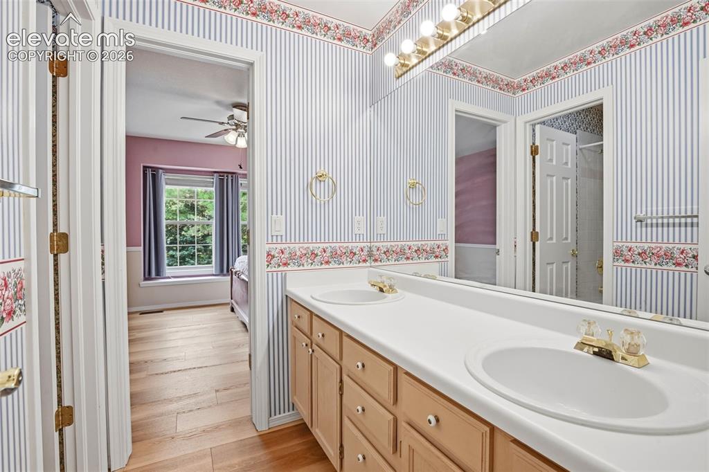 Image 29 of 40: Full attached bathrom with dual sinks and separate tub/shower combo