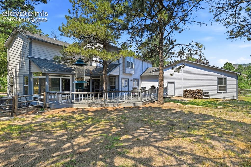 Image 40 of 44: Expansive outdoor deck with railing, siding exterior, and mature trees