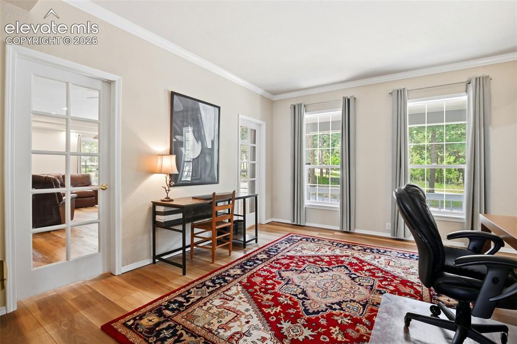 Image 6 of 40: The office has the same newer LVP flooring throughout, glass doors, and cro