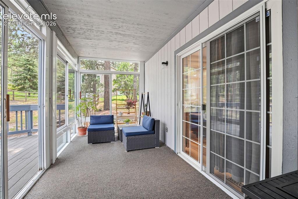 Image 9 of 40: Sun room / screened-in porch just off the main level living room addition.