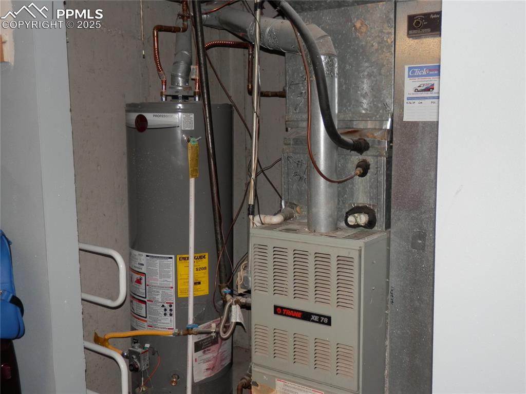 Image 28 of 29: Utility room featuring water heater and heating unit