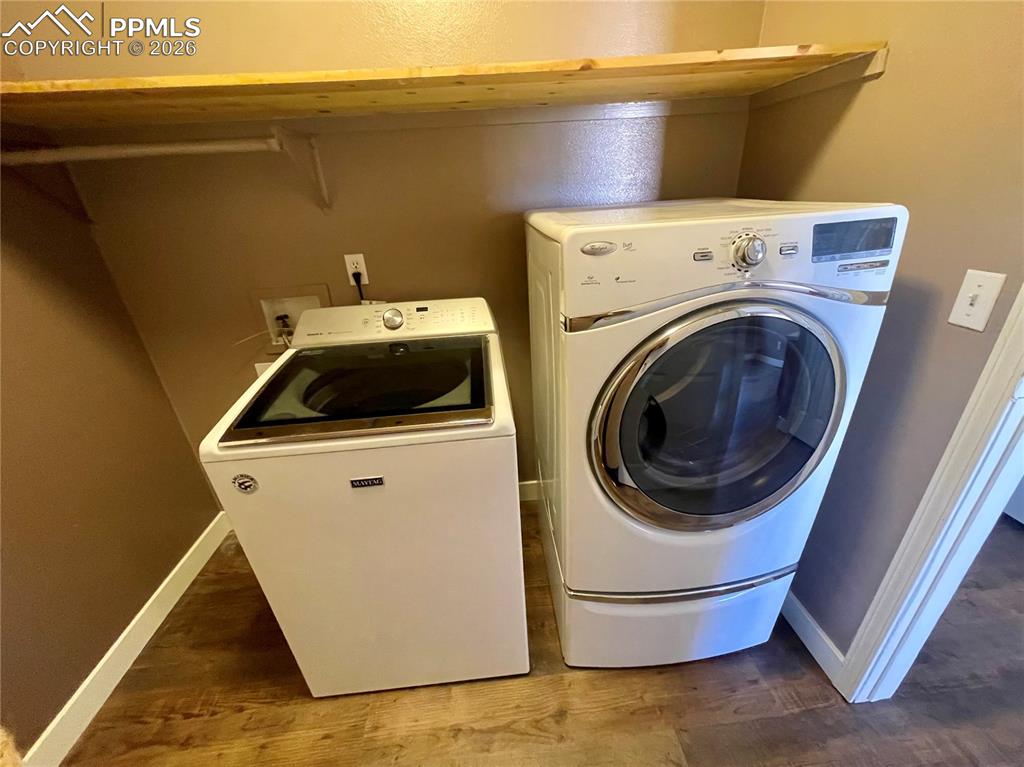 Image 14 of 29: Laundry room with dark wood-style floors and washer and dryer