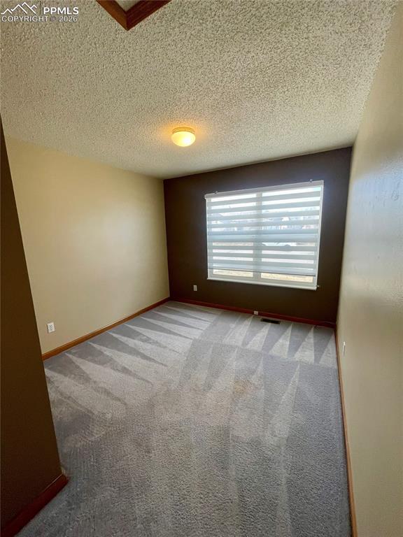 Image 9 of 29: Empty room with light carpet and a textured ceiling