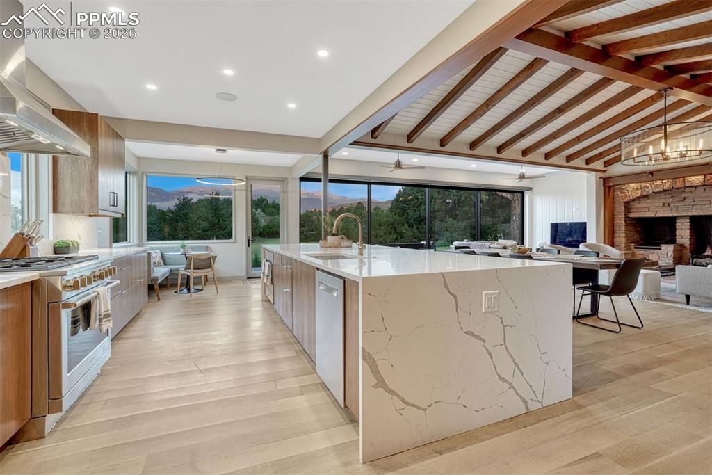 Image 3 of 46: Open-concept kitchen with quartz waterfall counters and white oak floors, p