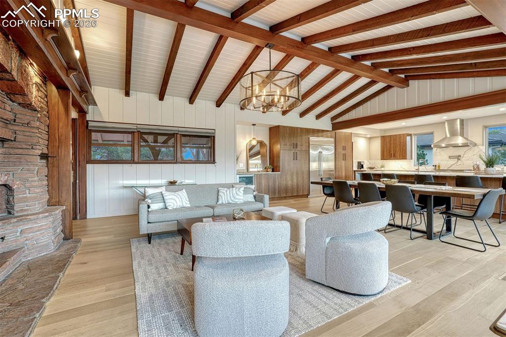 Image 39 of 46: Living area with fireplace, white oak hardwood floors, and window wall over