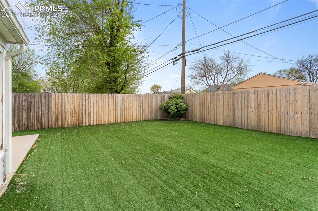 Image 22 of 32: Turf yard is fully fenced for pets and privacy!