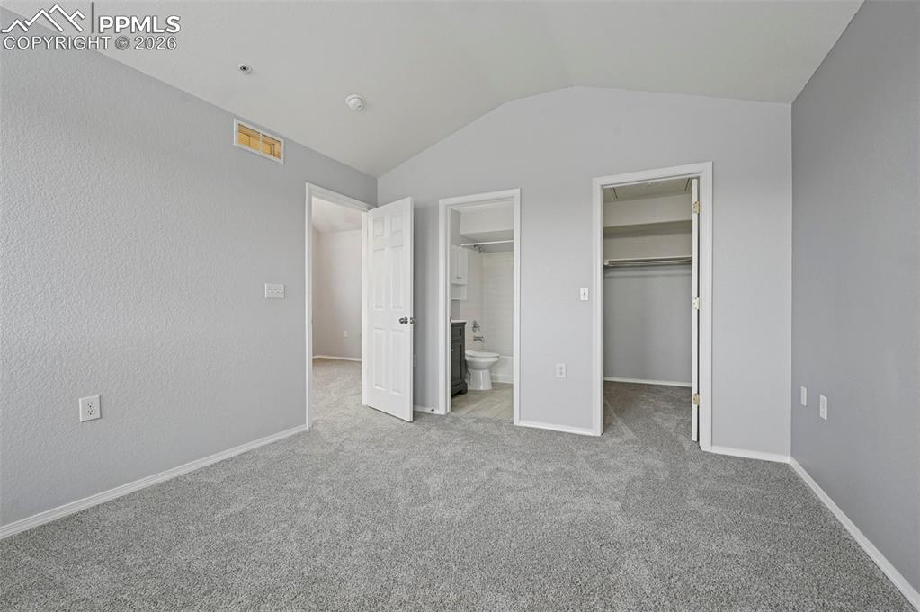 Image 11 of 29: Spacious primary bedroom featuring new plush carpet, a walk-in closet, and 