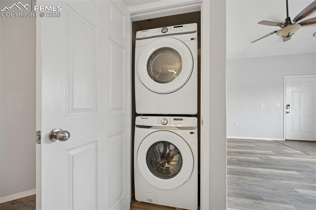 Image 21 of 29: Convenient in-unit laundry area featuring a stacked washer and dryer neatly