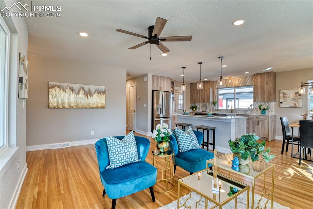 Image 12 of 35: Living area with a ceiling fan, light wood finished floors, and recessed li