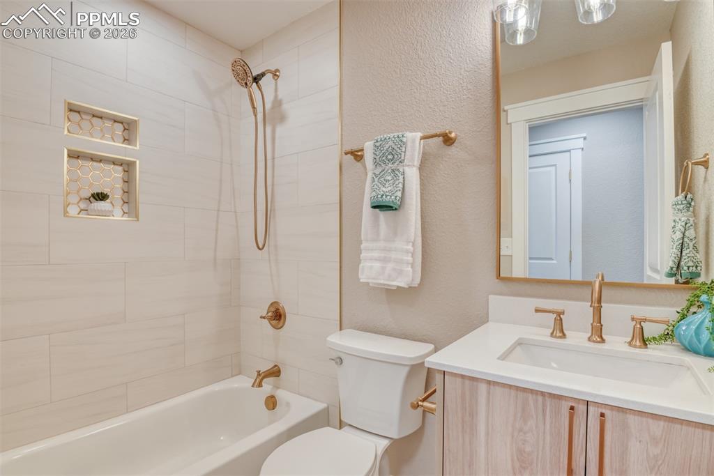 Image 24 of 30: Bathroom featuring vanity, tub / shower combination, and a textured wall