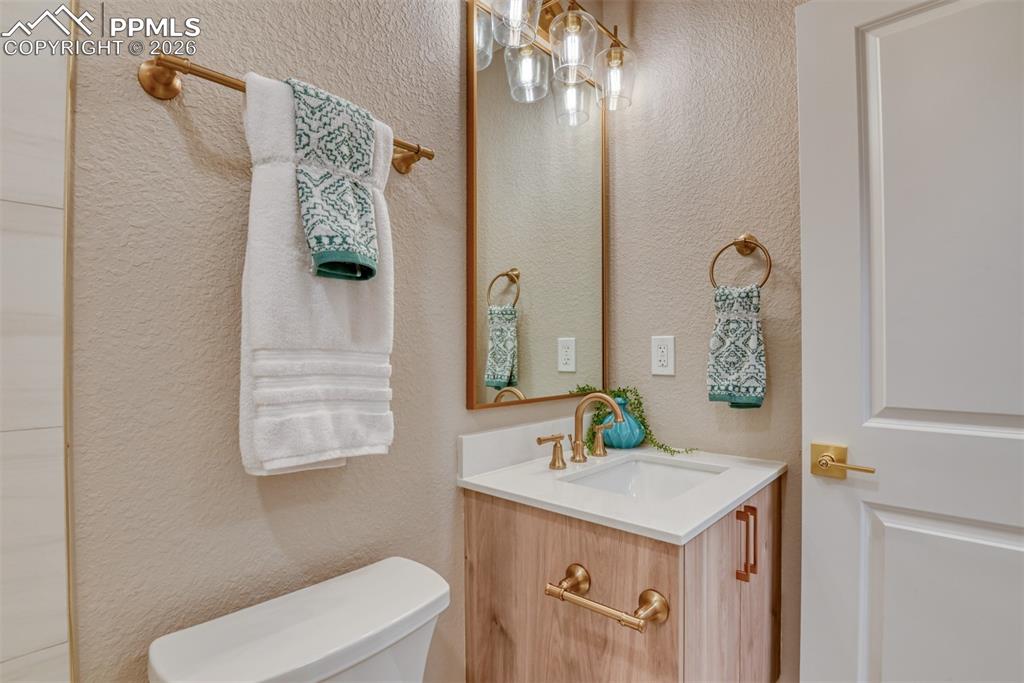 Image 25 of 30: Half bath featuring vanity and a textured wall