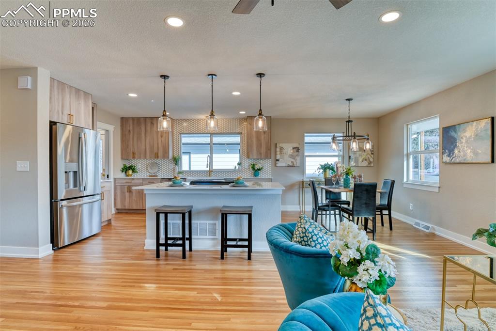 Image 8 of 30: Kitchen featuring pendant lighting, stainless steel refrigerator with ice d