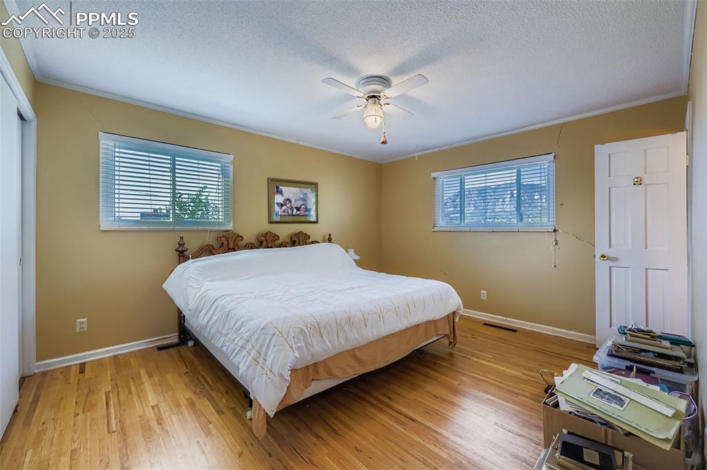 Image 10 of 23: Bedroom featuring light wood-style flooring, a textured ceiling, ornamental