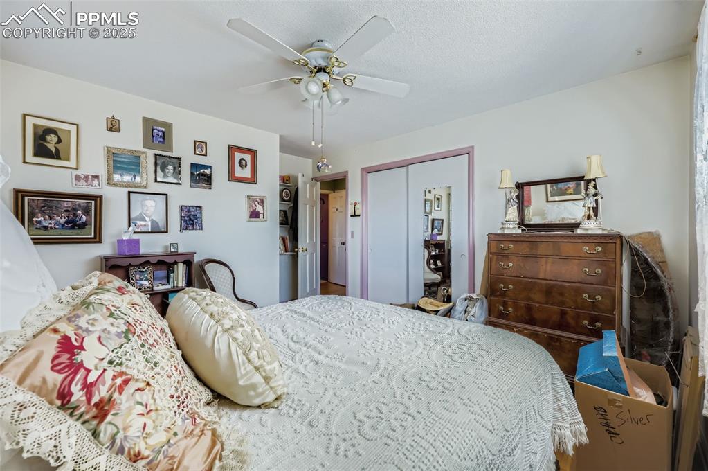 Image 15 of 23: Bedroom with a closet, a ceiling fan, and a textured ceiling