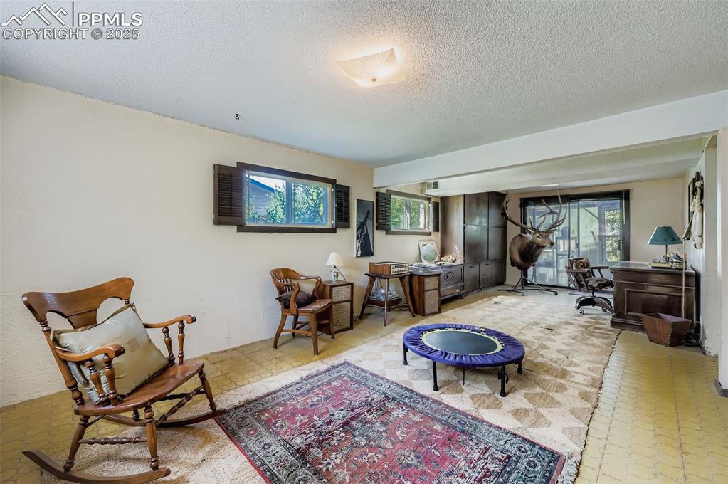 Image 16 of 23: Sitting room with a textured ceiling and tile patterned floors