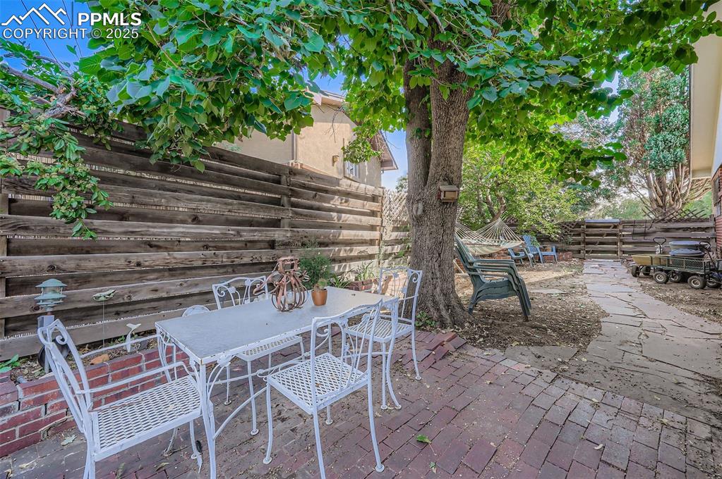 Image 21 of 23: Fenced backyard featuring a patio area and outdoor dining area