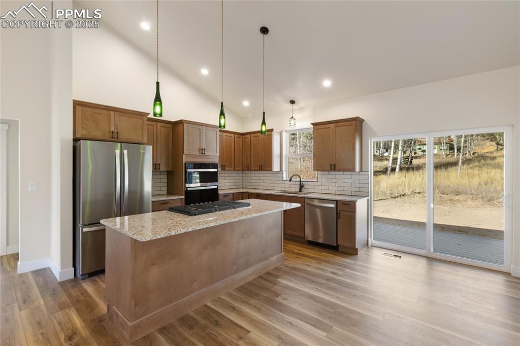 Image 12 of 38: Kitchen with decorative backsplash, appliances with stainless steel finishe
