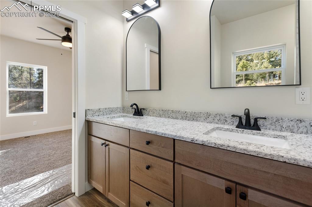 Image 24 of 38: Full bathroom with plenty of natural light, double vanity, ceiling fan, and