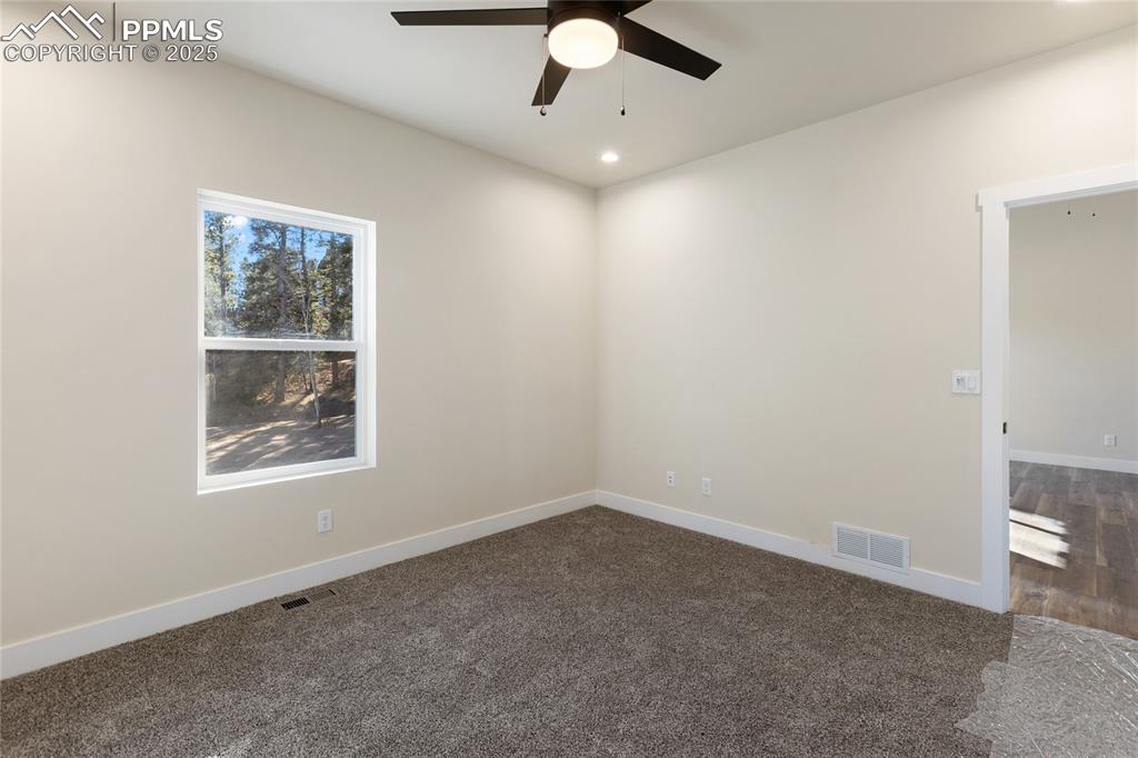 Image 25 of 38: Spare room featuring dark colored carpet, recessed lighting, and ceiling fa