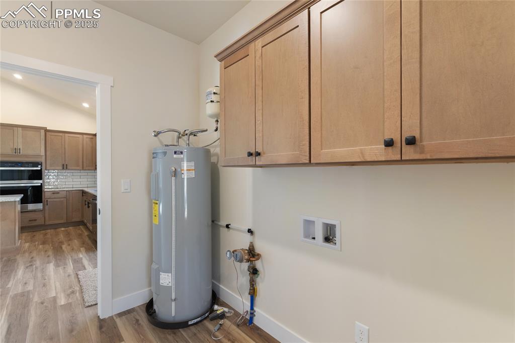 Image 36 of 38: Washroom featuring light wood finished floors, electric water heater, reces