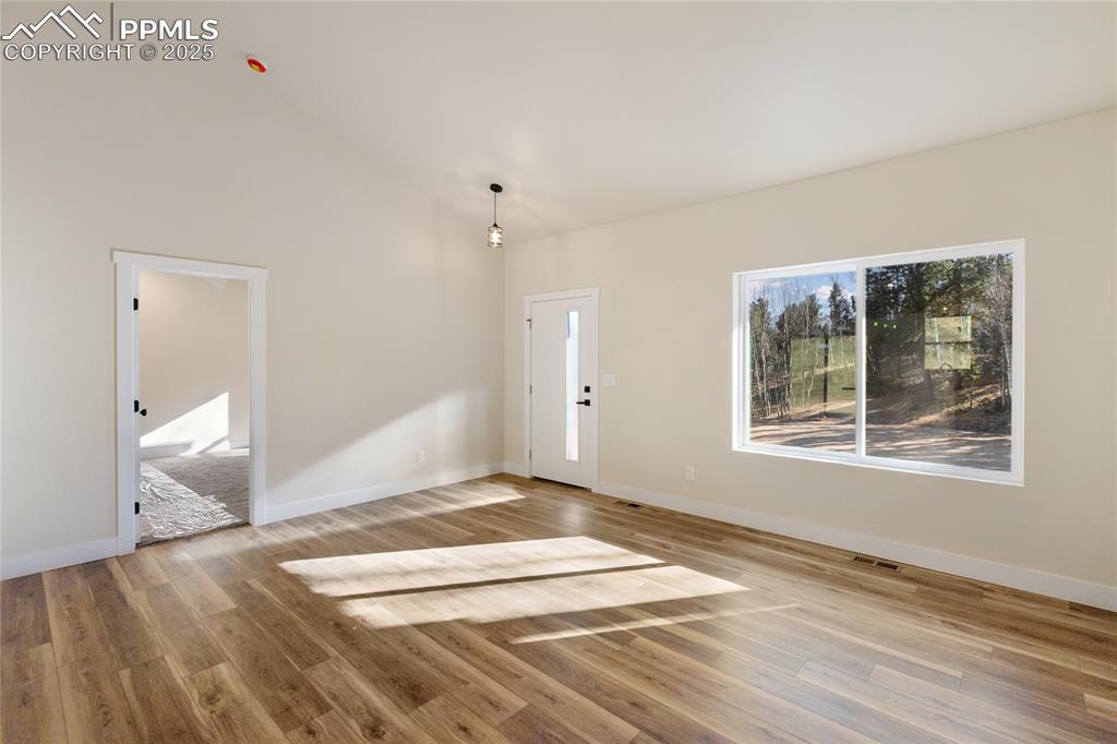 Image 8 of 38: Foyer with light wood-style floors and high vaulted ceiling