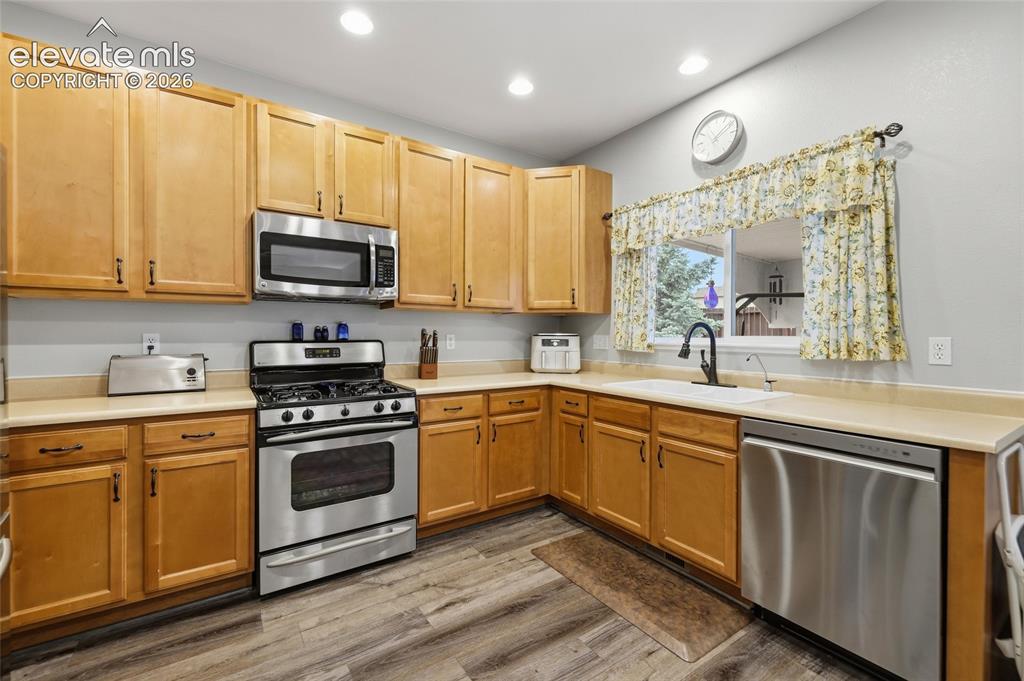 Image 10 of 41: Kitchen featuring wood-finish cabinetry, stainless steel appliances, solid 