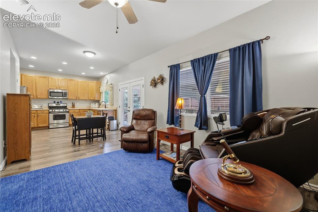 Image 13 of 41: Living area featuring LVP flooring, a ceiling fan, gas fireplace, and built