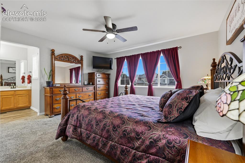 Image 15 of 41: Bedroom with carpet and a ceiling fan. Private en-suite bath
