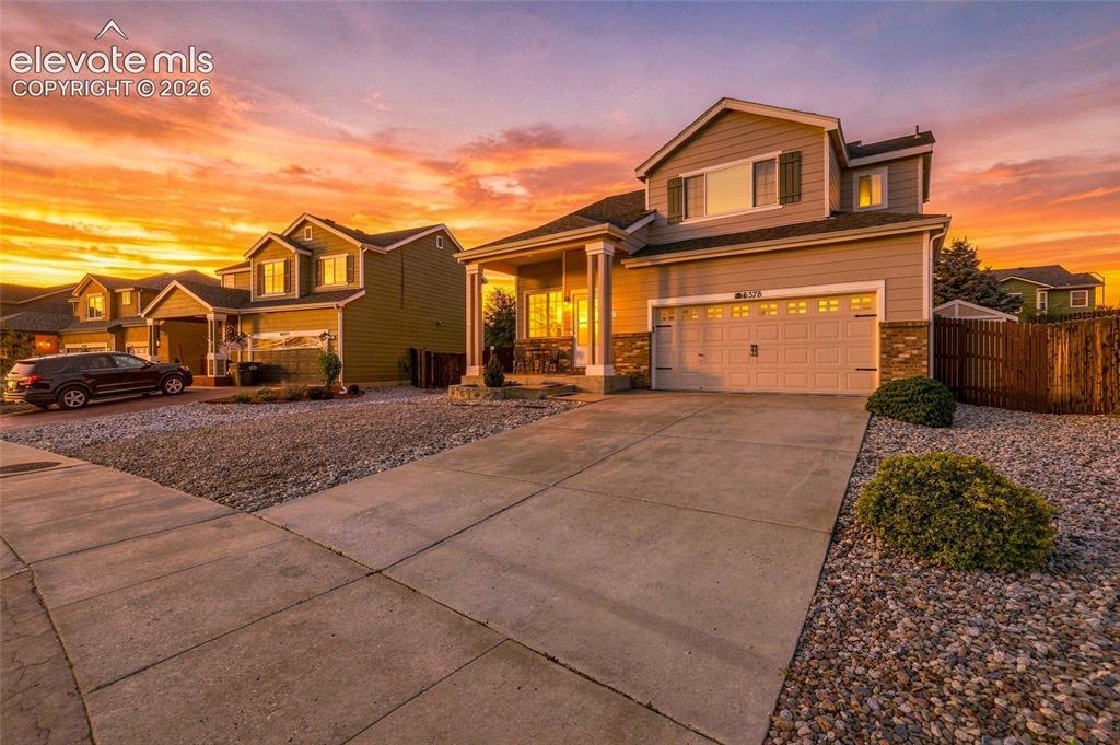 Image 3 of 41: Two-story exterior with a covered front porch, an attached two-car garage, 