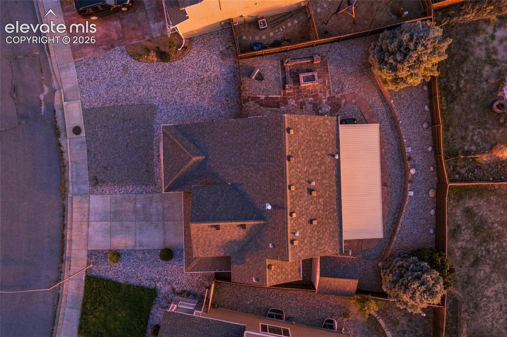 Image 34 of 41: Gable roofline, asphalt shingle roofing, gravel landscaping, paved concrete