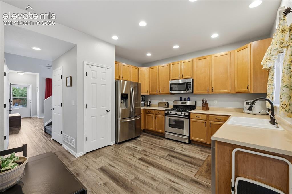 Image 9 of 41: Kitchen featuring wood-finish flooring, light wood cabinetry, stainless ste