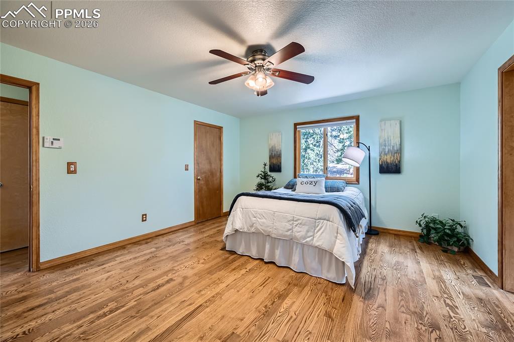 Image 15 of 37: Primary bedroom with wood flooring and walk-in closet