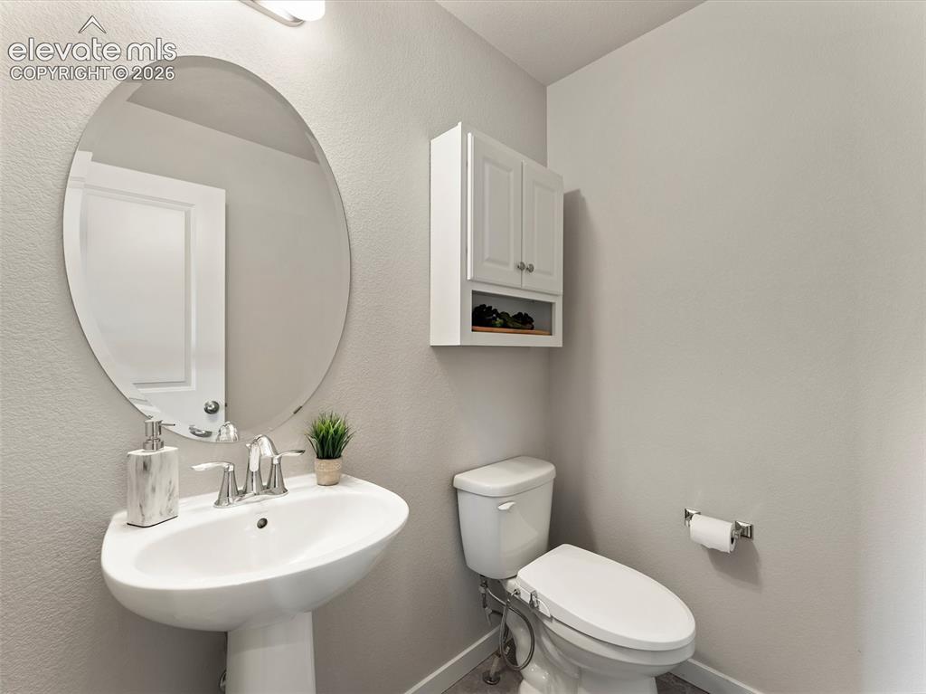 Image 19 of 46: Pedestal sink with chrome faucet, complemented by an oval-shaped mirror and
