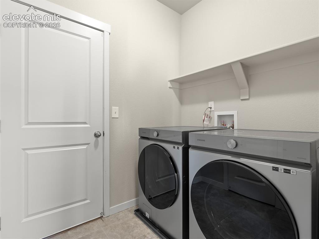 Image 20 of 46: Dedicated laundry area featuring a white built-in shelf, neutral wall tones