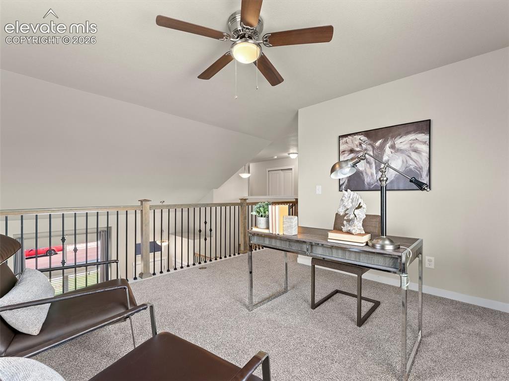 Image 22 of 46: Versatile loft space featuring vaulted ceilings, a ceiling fan with light f