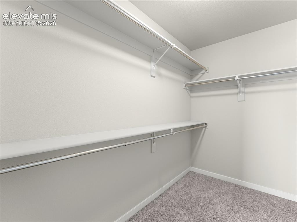 Image 29 of 46: Walk-in closet featuring white wire shelving and hanging rods