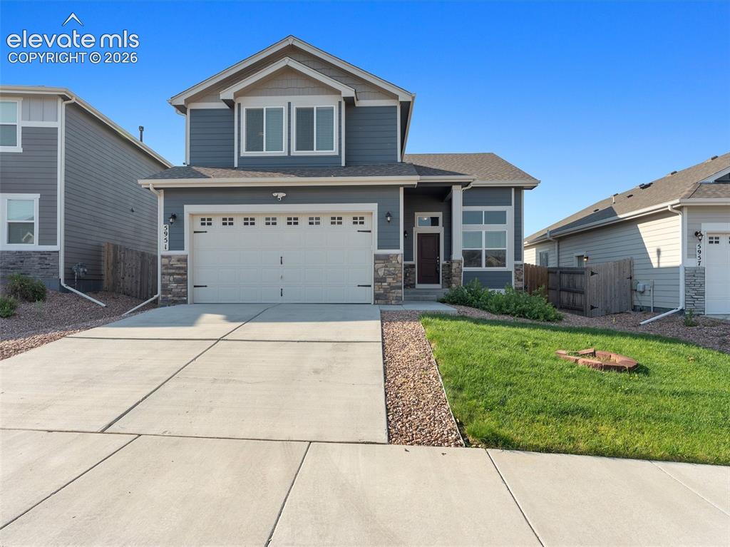 Image 3 of 46: Two-story residence featuring a two-car garage, stone and siding exterior, 